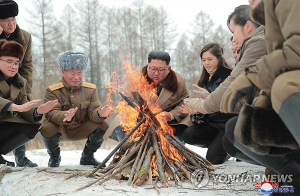 조선중앙통신은 김 위원장이 리 여사, 고위간부들과 함께 모닥불을 피우며 손을 쬐는 사진을 공개했다.  [사진=연합뉴스]