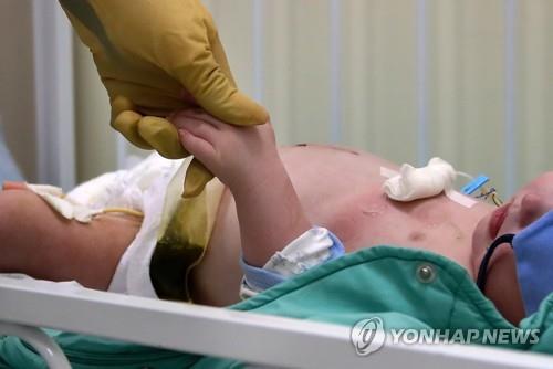 모스크바 국립아동건강연구병원 의료진이 유아 코로나19 환자를 보살피고 있는 모습. [사진=연합뉴스]