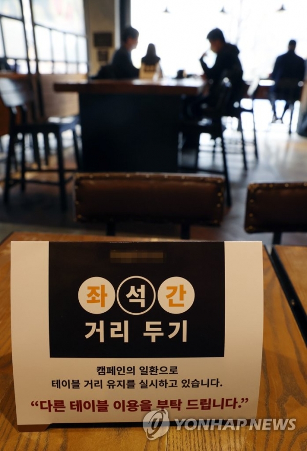코로나19 확산세가 커진 수도권의 '사회적 거리두기'가 1.5단계로 격상되는 가운데 17일 서울시내 한 카페에 좌석 간 거리두기 안내문이 놓여 있다. [사진=연합뉴스]