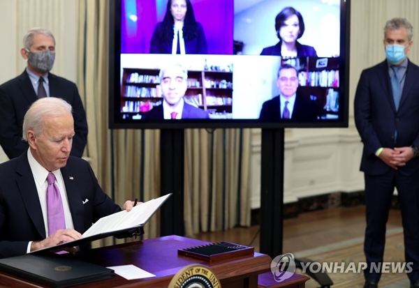 조 바이든 미국 대통령이 21일(현지시간) 백악관에서 앤서니 파우치 국립알레르기·전염병연구소 소장(왼쪽)이 지켜보는 가운데 코로나19 대응에 관한 행정명령에 서명하고 있다. [사진=연합뉴스]