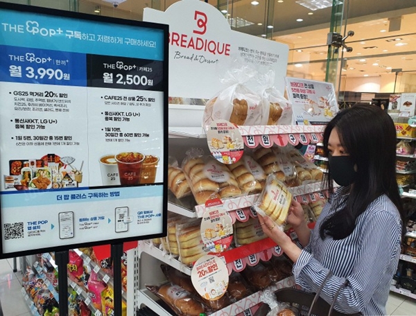 GS25에서 소비자가 더팝플러스 구독 서비스 상품인 브레디크 빵을 살펴보고 있다. [사진=GS25 제공]