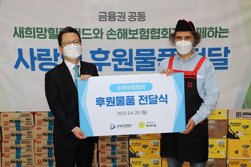 정지원 손해보험협회 회장(왼쪽)이 김하종 안나의집 신부(오른쪽)에게 후원물품을 전하고 있다. [사진=손해보험협회 제공]