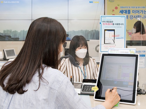 서울 서대문 농협은행 본점 영업부에서 고객이 전자창구(PPR) 신(新)시스템을 활용하여 거래를 하고 있다. [사진=농협은행 제공]