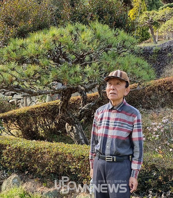 평생 나무심기로 초암정원을 일군 김재기 씨가  최고의 소나무라고 자랑하는 철갑송 앞에 서 있다.
