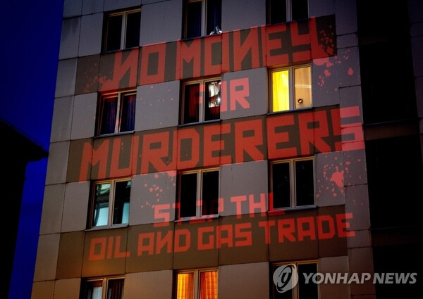 독일 시민활동가들이 지난 4일 러시아산 에너지 금지를 촉구하는 메시지를 담은 '살인자들을 위한 돈은 없다. 석유와 가스 거래를 중단하라(NO MONEY FOR MURDERERS, STOP THE OIL AND GAS TRADE)'는 구호를 프랑크푸르트의 러시아 영사관 건물 벽면에 붉은색 조명으로 비추고 있다. [사진=AP/연합뉴스]