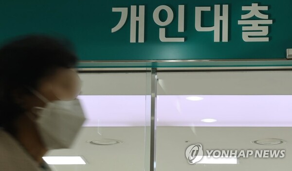 지난해 연간 가계대출 잔액이 관련 통계 집계가 시작된 지 18년 만에 처음으로 감소했다는 발표가 나온 12일 서울 한 은행에서 시민이 대출창구 앞을 지나고 있다. [사진=연합뉴스]