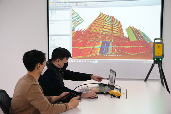 롯데건설 관계자가 3D 스캐너를 활용한 기존 아파트 모델링 데이터를 확인하고 있다. [사진=롯데건설 제공]