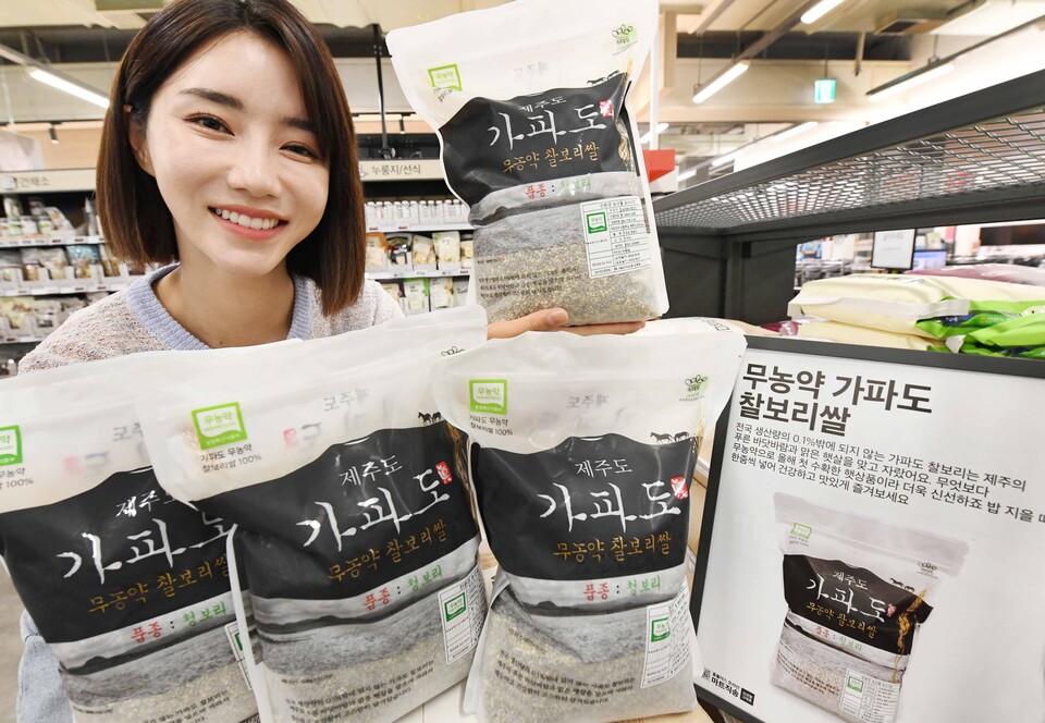 모델이 서울 등촌동 ‘홈플러스 메가푸드마켓’ 강서점에서 지역 농가 상생 대표 상품인 ‘가파도 찰보리쌀’을 선보이고 있다. [사진=홈플러스 제공]