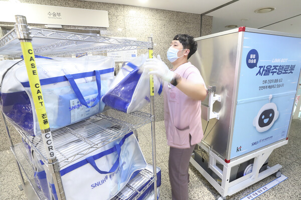 분당서울대병원 직원이 자동이송 로봇에서 물품을 꺼내는 모습. [사진=KT 제공]