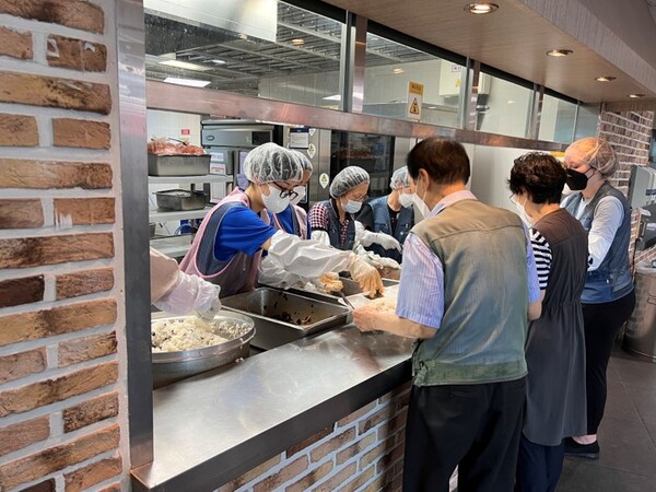 bhc그룹의 '해바라기 봉사단'이 우리마포복지관에서 급식 봉사활동을 하고 있다. [사진=bhc 제공]
