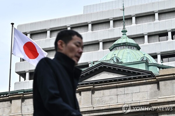 일본은행(BOJ)이 17년 만에 금리 인상을 단행한 19일 한 도쿄 시민이 BOJ 본관 앞을 지나고 있다. [사진=AFP/연합뉴스]